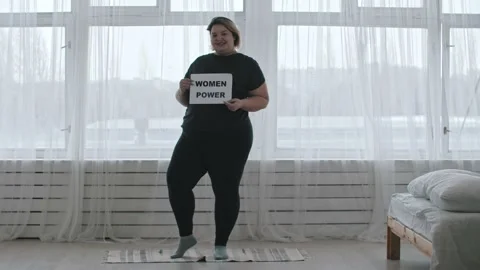 Concept body positivity - a chubby smiling woman holds a sign with the Stock Footage 152727049