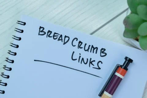 Concept of BreadCrumb Links write on book isolated on Wooden Table. Fotos de archivo