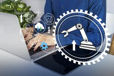 The concept of businessman using computer system to manage robotic arms in .. 写真素材