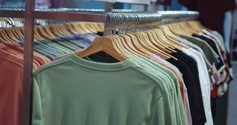 The concept of buying clothes. Close-up of colored clothes on hangers in a Stock Footage 250855522