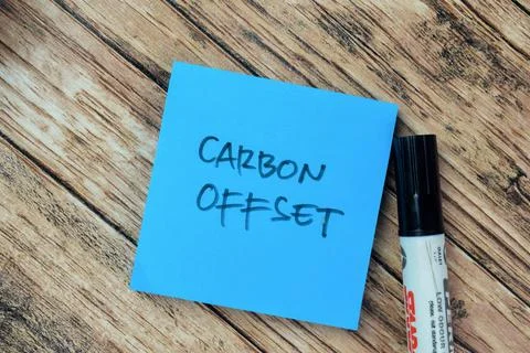 Concept of Carbon Offset write on sticky notes isolated on Wooden Table. Stock Photos