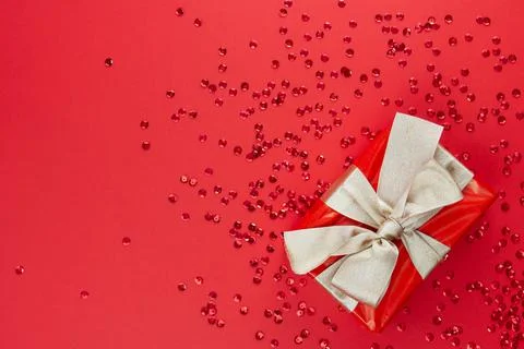 The concept of celebrating different holidays. Gift box with gold bow and red Stock Photos