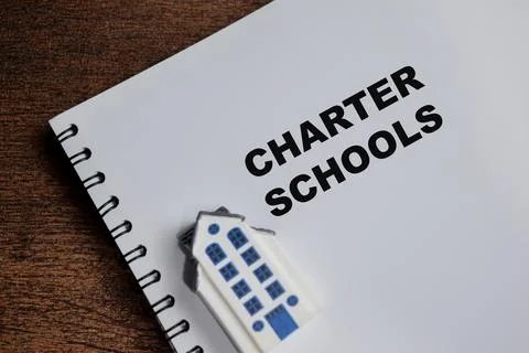 Concept of charter schools write on book isolated on Wooden Table. Stock Photos