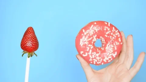 Concept of choice between donut and strawberry. female hands with red nail Stock-Footage 107743551