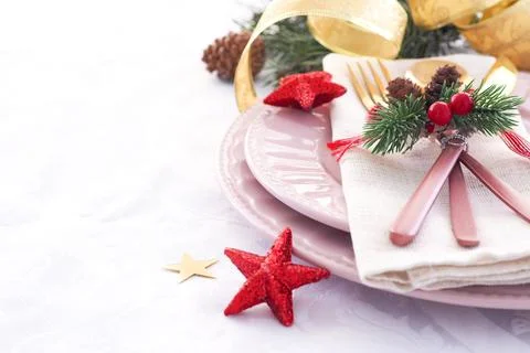 Concept of christmas table setting. two pink plates and pink and gold cutlery Stock Photos