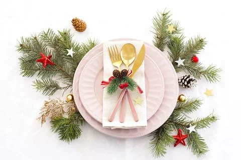 Concept of christmas table setting. two pink plates and pink and gold cutlery Stock Photos