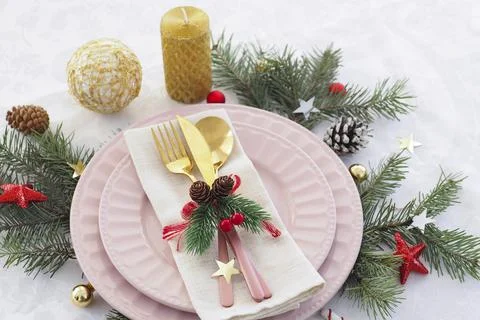 Concept of christmas table setting. two pink plates and pink and gold cutlery Stock Photos