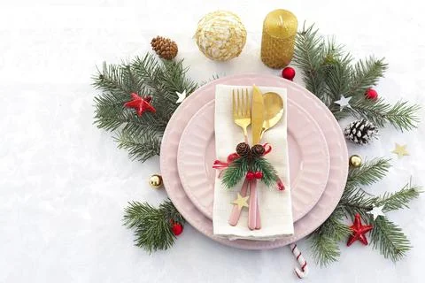 Concept of christmas table setting. two pink plates and pink and gold cutlery Stock Photos
