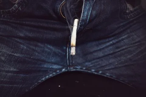 Concept cigarettes causes sexual dysfunction. burnt cigarette sticking out of Stock Photos