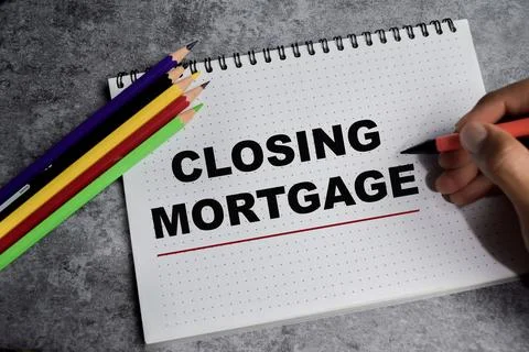 Concept of closing mortgage write on book isolated on Wooden Table. Stock Photos