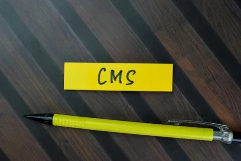 Concept of CMS write on sticky notes isolated on Wooden Table. 스톡 사진
