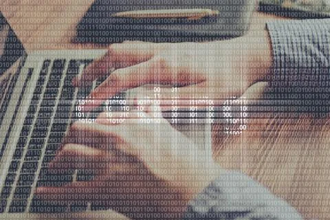 The concept of coding from a binary code on the background of a person typing Stock Photos