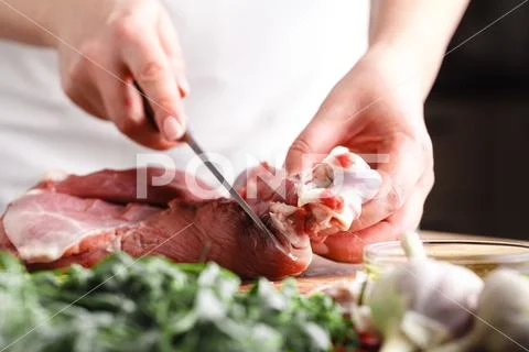 The concept of cooking meat. The chef, the butcher, cuts raw meat with beef, Stock Photos