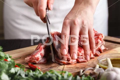The concept of cooking meat. The chef, the butcher, cuts raw meat with beef, Stock Photos