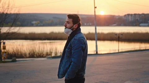 Concept of Coronavirus in the empty park at sunset quarantine man with a Stock Footage 127326726