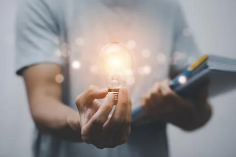 Concept creativity with light bulbs and energy power, Man hand holding light  Stock Photos