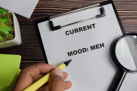 Concept of current mood meh write on clipboard isolated on Wooden Table. Stock Photos