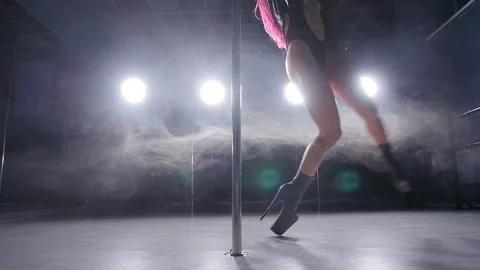 Concept of dance and acrobatics. Young slim woman pole dancing in dark interior Stock Footage 103410011