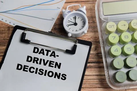 Concept of data driven decisions write on clipboard isolated on Wooden Table. Stock Photos