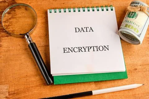 The concept of data encryption is represented on a notepad alongside a magnif Foto stock