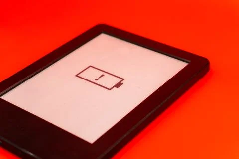 Concept A dead battery on a modern device, a device without a charger on a red Stock Photos