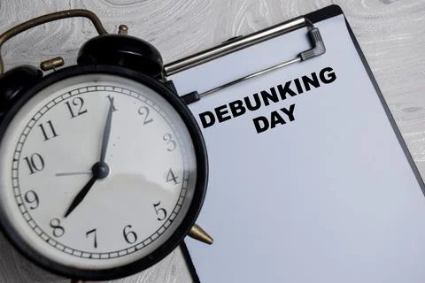 Concept of Debunking Day write on paperwork isolated on Wooden Table. Stock Photos