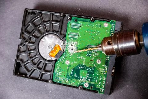Concept of deleting big data by drilling a hole into the harddisk Stock Photos
