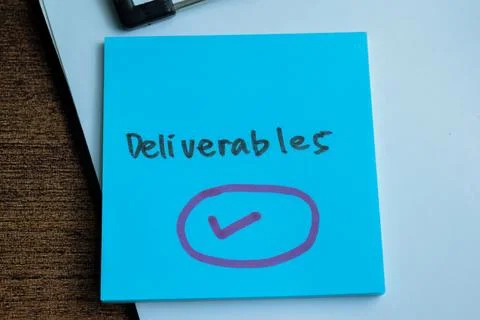 Concept of Deliverables write on sticky notes isolated on Wooden Table. Stock Photos