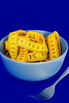 The concept of the diet. The fork rewound centimeter lying on plate closeup Stock Photos