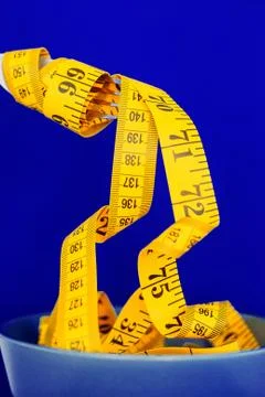 The concept of the diet. The fork rewound centimeter lying on plate closeup Stock Photos