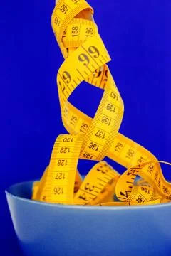 The concept of the diet. The fork rewound centimeter lying on plate closeup Stock Photos