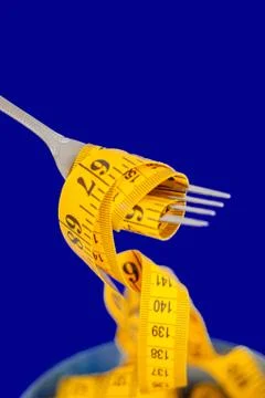 The concept of the diet. The fork rewound centimeter lying on plate closeup Stock Photos