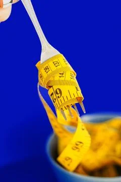 The concept of the diet. The fork rewound centimeter lying on plate closeup Stock Photos