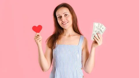 The concept of a difficult choice between money and love. A woman holds money Stock Photos