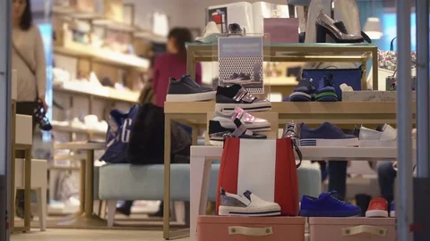 Concept of difficult choice process.. Young women on shopping in a shoe store on Stock-Footage 73966884