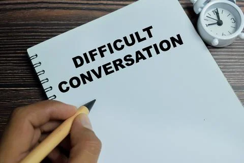 Concept of difficult conversation write on book isolated on Wooden Table. Stock Photos
