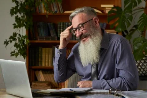 Concept of distance learning. Teacher tutor looking at laptop and talking wit Stock Photos