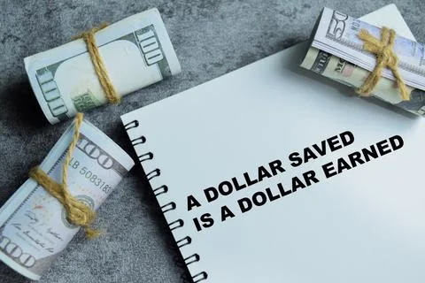 Concept of a dollar saved is a dollar earned write on book Fotos de archivo