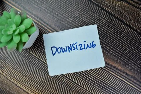 Concept of Downsizing write on sticky notes isolated on Wooden Table. Foto stock