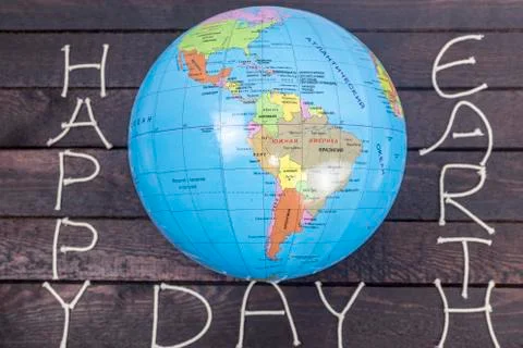 Concept-Earth Day. Globe with the text: Happy Earth Day lays on wooden backgr Stock Photos