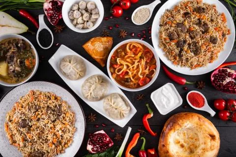 The concept of Eastern festive cuisine. Assorted Uzbek food set, pilaf, samsa Stock Photos