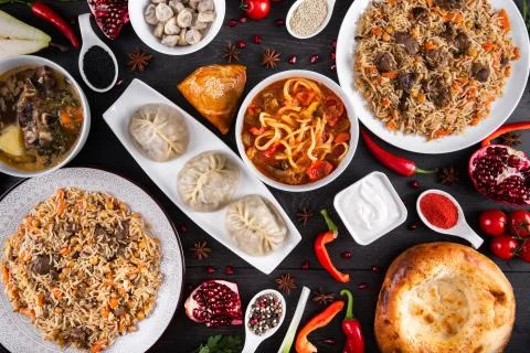 The concept of Eastern festive cuisine. Assorted Uzbek food set, pilaf, samsa Stock Photos