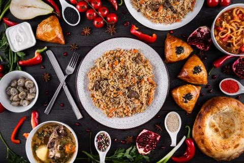 The concept of Eastern festive cuisine. Assorted Uzbek food set, pilaf, samsa Stock Photos