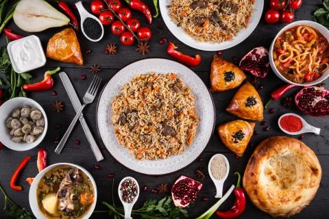 The concept of Eastern festive cuisine. Assorted Uzbek food set, pilaf, samsa Stock Photos