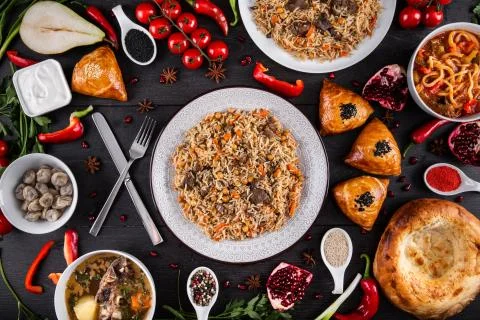 The concept of Eastern festive cuisine. Assorted Uzbek food set, pilaf, samsa Stock Photos