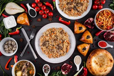 The concept of Eastern festive cuisine. Assorted Uzbek food set, pilaf, samsa Stock Photos