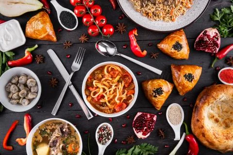 The concept of Eastern festive cuisine. Assorted Uzbek food set, pilaf, samsa Stock Photos