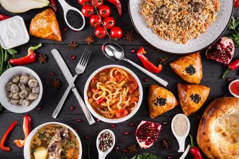 The concept of Eastern festive cuisine. Assorted Uzbek food set, pilaf, samsa Stock Photos