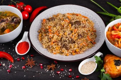 The concept of Eastern festive cuisine. Assorted Uzbek food set, pilaf, samsa Stock Photos