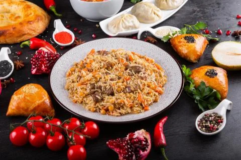 The concept of Eastern festive cuisine. Assorted Uzbek food set, pilaf, samsa Stock Photos